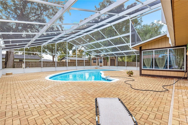 view of swimming pool featuring glass enclosure and a patio area