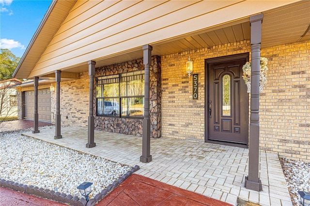 doorway to property with a porch and a garage