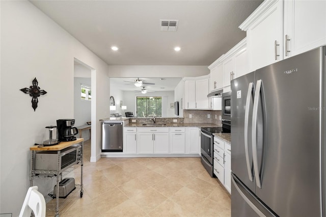 kitchen with backsplash, stone counters, ceiling fan, white cabinetry, and stainless steel appliances