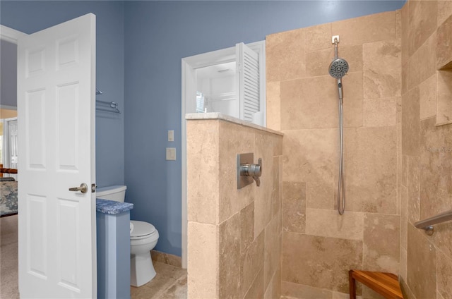 bathroom featuring a tile shower and toilet