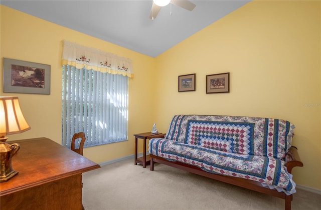 carpeted home office with ceiling fan and vaulted ceiling