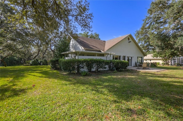 view of side of property featuring a yard and a patio area