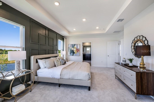 carpeted bedroom featuring a tray ceiling and multiple windows