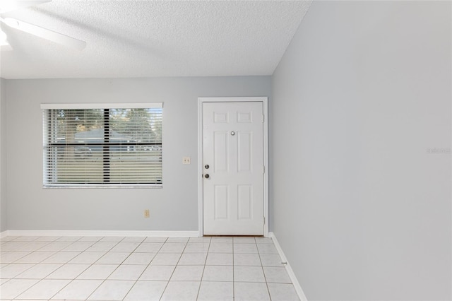 tiled entryway featuring ceiling fan and a textured ceiling