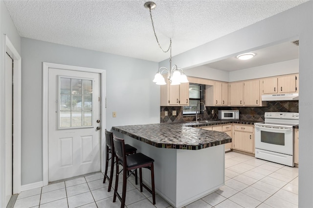 kitchen with tasteful backsplash, kitchen peninsula, a breakfast bar, and white appliances