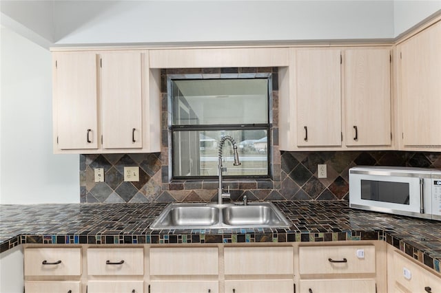 kitchen with decorative backsplash, light brown cabinetry, tile counters, and sink