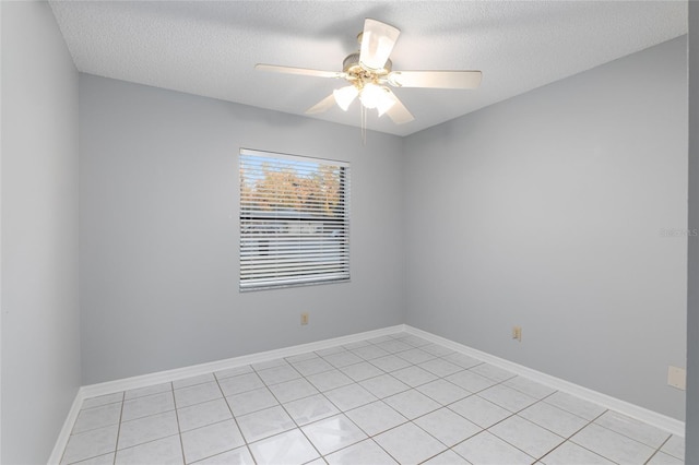 spare room featuring light tile patterned floors, a textured ceiling, and ceiling fan