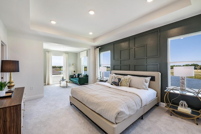 carpeted bedroom with a raised ceiling