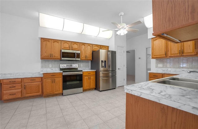 kitchen with backsplash, stainless steel appliances, ceiling fan, sink, and light tile patterned flooring