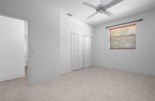 unfurnished bedroom with ceiling fan and a closet