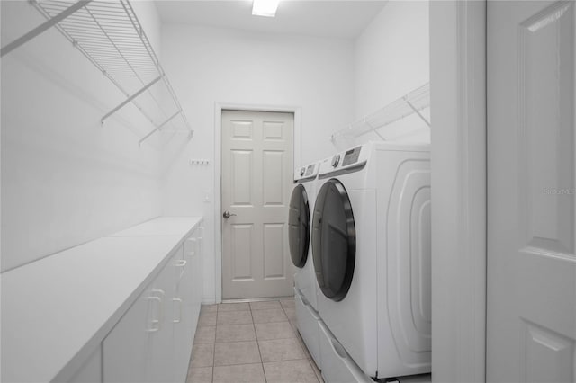 clothes washing area with washer and dryer and light tile patterned floors