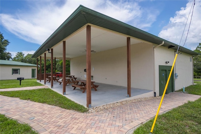 back of house with ceiling fan, a yard, and a patio