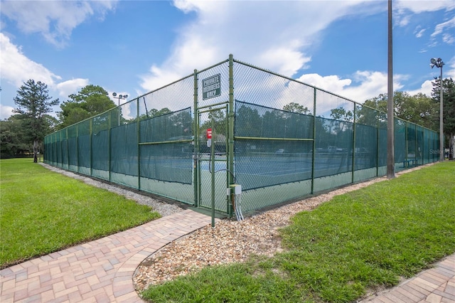 view of tennis court featuring a yard