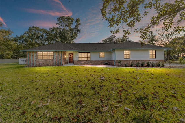 ranch-style house with brick siding and a lawn