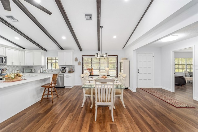 dining room with vaulted ceiling with beams, dark hardwood / wood-style floors, and plenty of natural light