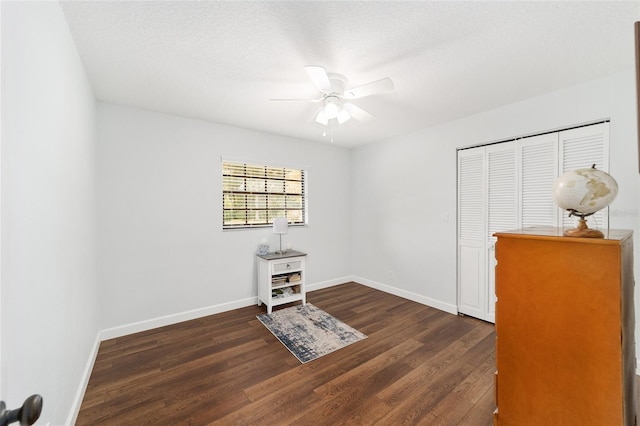 interior space with ceiling fan, dark hardwood / wood-style flooring, a textured ceiling, and a closet