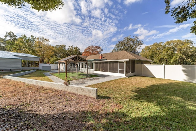 rear view of property with a lawn and a sunroom