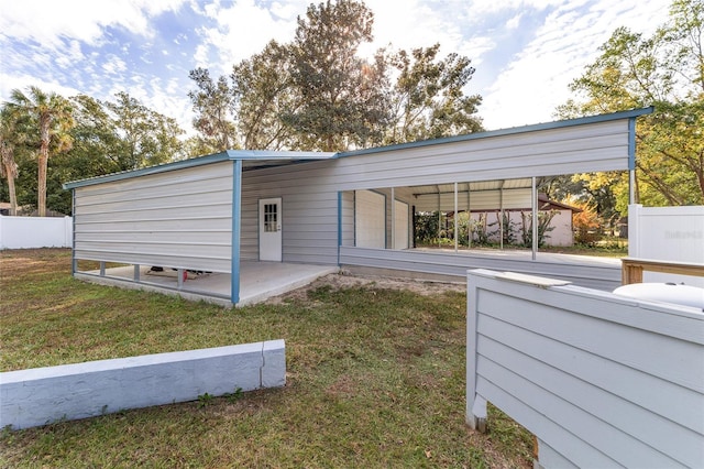 exterior space featuring a lawn and a carport