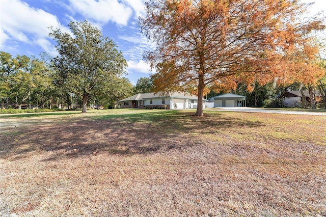 view of front facade with a front lawn, an outdoor structure, and a garage