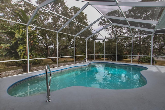 view of pool featuring glass enclosure and a patio