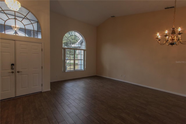 entrance foyer featuring dark hardwood / wood-style flooring, an inviting chandelier, and lofted ceiling