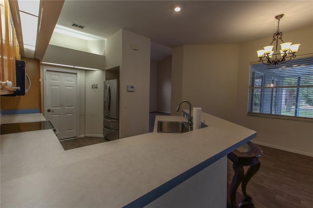 kitchen with stainless steel fridge, sink, decorative light fixtures, an inviting chandelier, and dark hardwood / wood-style floors