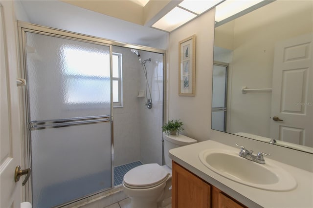 bathroom with tile patterned floors, vanity, toilet, and walk in shower