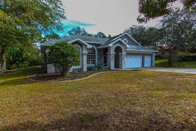 view of front of property with a yard and a garage