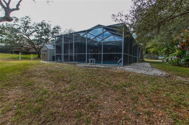 rear view of property featuring glass enclosure and a yard