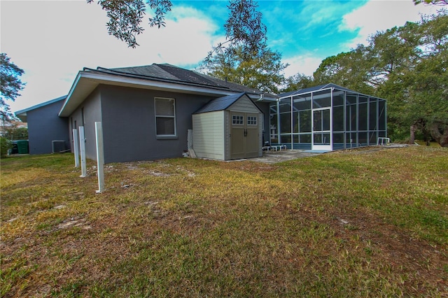 back of property featuring a yard and a shed