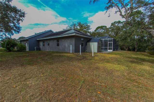 back of property featuring a lawn and glass enclosure