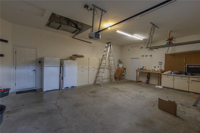 garage with a workshop area, white fridge, and a garage door opener