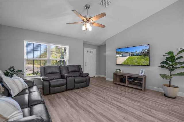 living room with ceiling fan, lofted ceiling, and light wood-type flooring