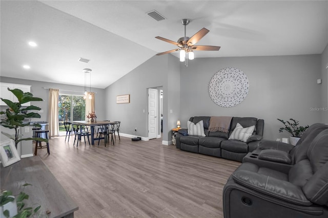 living room featuring ceiling fan, hardwood / wood-style floors, and lofted ceiling