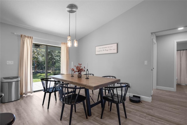 dining area with light wood-type flooring and lofted ceiling