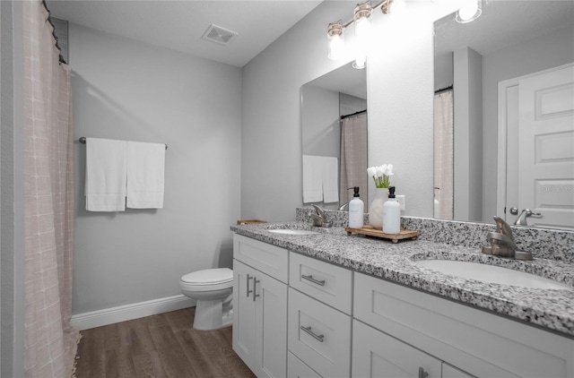 bathroom featuring hardwood / wood-style flooring, vanity, and toilet