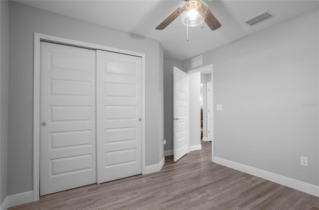 unfurnished bedroom featuring light wood-type flooring, a closet, and ceiling fan