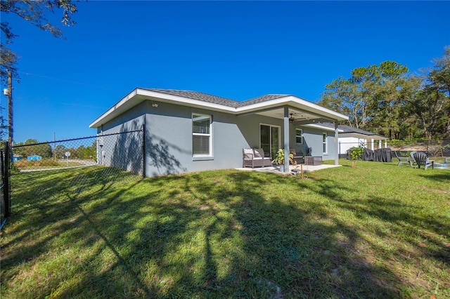 rear view of property with an outdoor hangout area, a patio area, and a yard