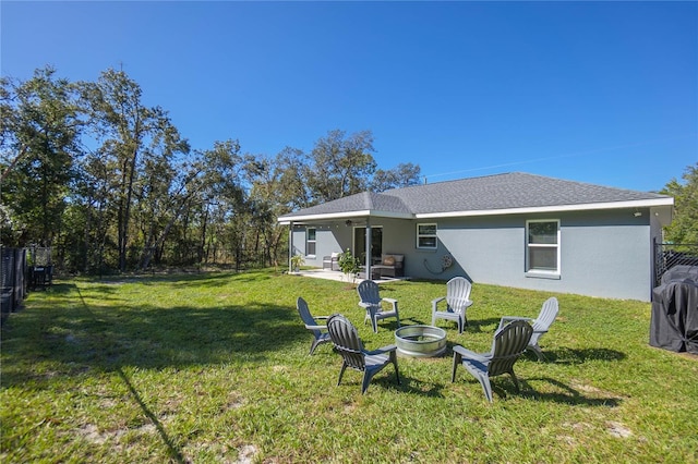 rear view of house with a lawn, a patio, and an outdoor fire pit