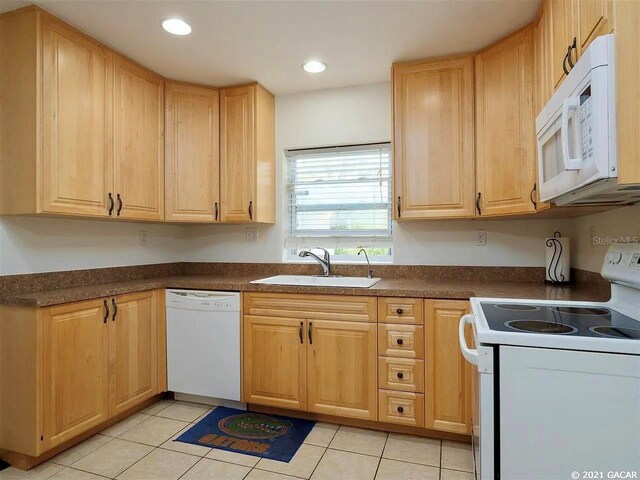 kitchen featuring sink, light tile patterned floors, white appliances, and light brown cabinets