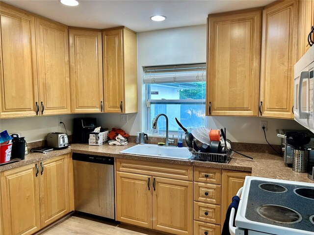 kitchen with white appliances, sink, and light hardwood / wood-style flooring