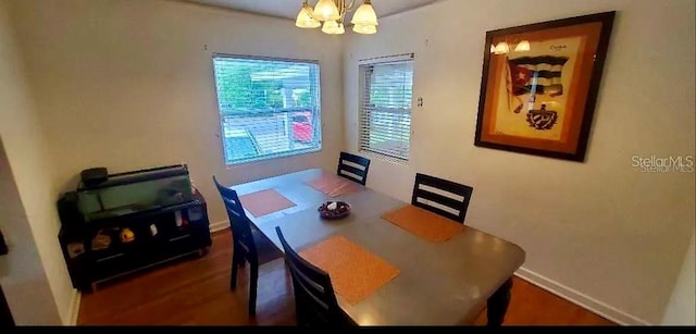 dining area featuring wood-type flooring and an inviting chandelier