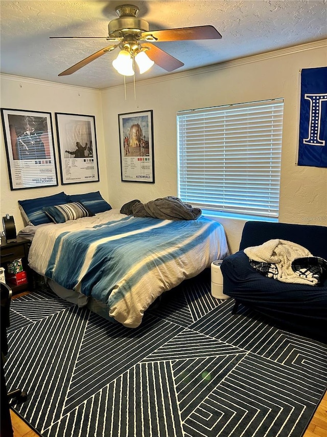 bedroom with wood-type flooring, a textured ceiling, ceiling fan, and crown molding