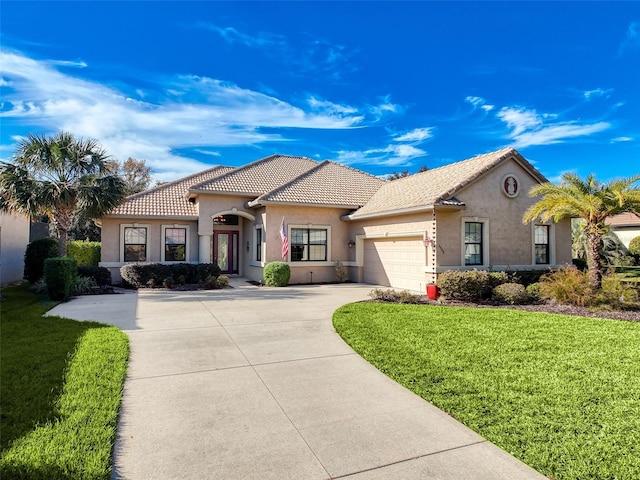 mediterranean / spanish-style home featuring a garage and a front lawn