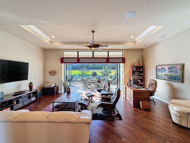 living room with dark hardwood / wood-style floors, a raised ceiling, ceiling fan, and crown molding