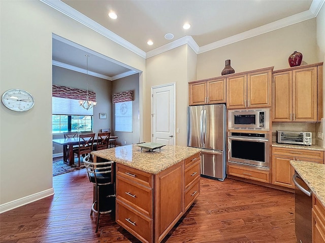 kitchen with hanging light fixtures, stainless steel appliances, a kitchen island, and dark hardwood / wood-style floors