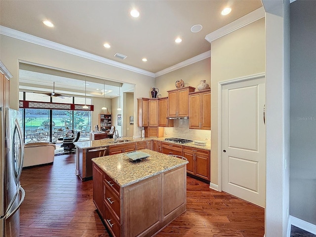 kitchen featuring kitchen peninsula, appliances with stainless steel finishes, dark hardwood / wood-style flooring, and a kitchen island