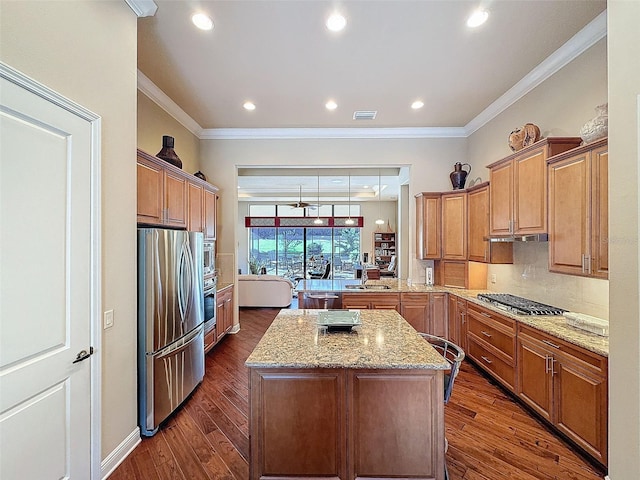 kitchen featuring a center island, stainless steel appliances, dark hardwood / wood-style floors, and ornamental molding