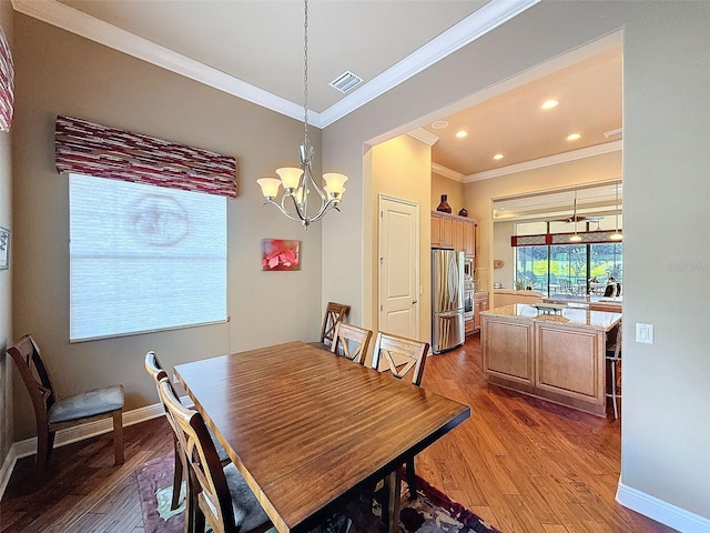 dining room featuring a notable chandelier, wood-type flooring, and crown molding