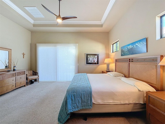 bedroom featuring a raised ceiling, multiple windows, and ceiling fan